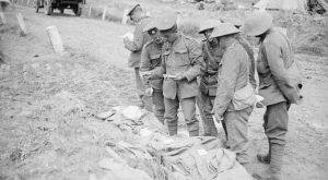 مجموعة من الرجال يفرزون في كومة كبيرة من الحقائب التي تحتوي على رسائل إلى ومن الجنود